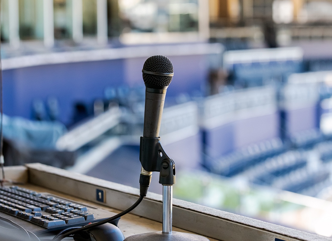 Blog - Microphone Resting in Holder on Desk of Announcers Booth for Baseball Stadium