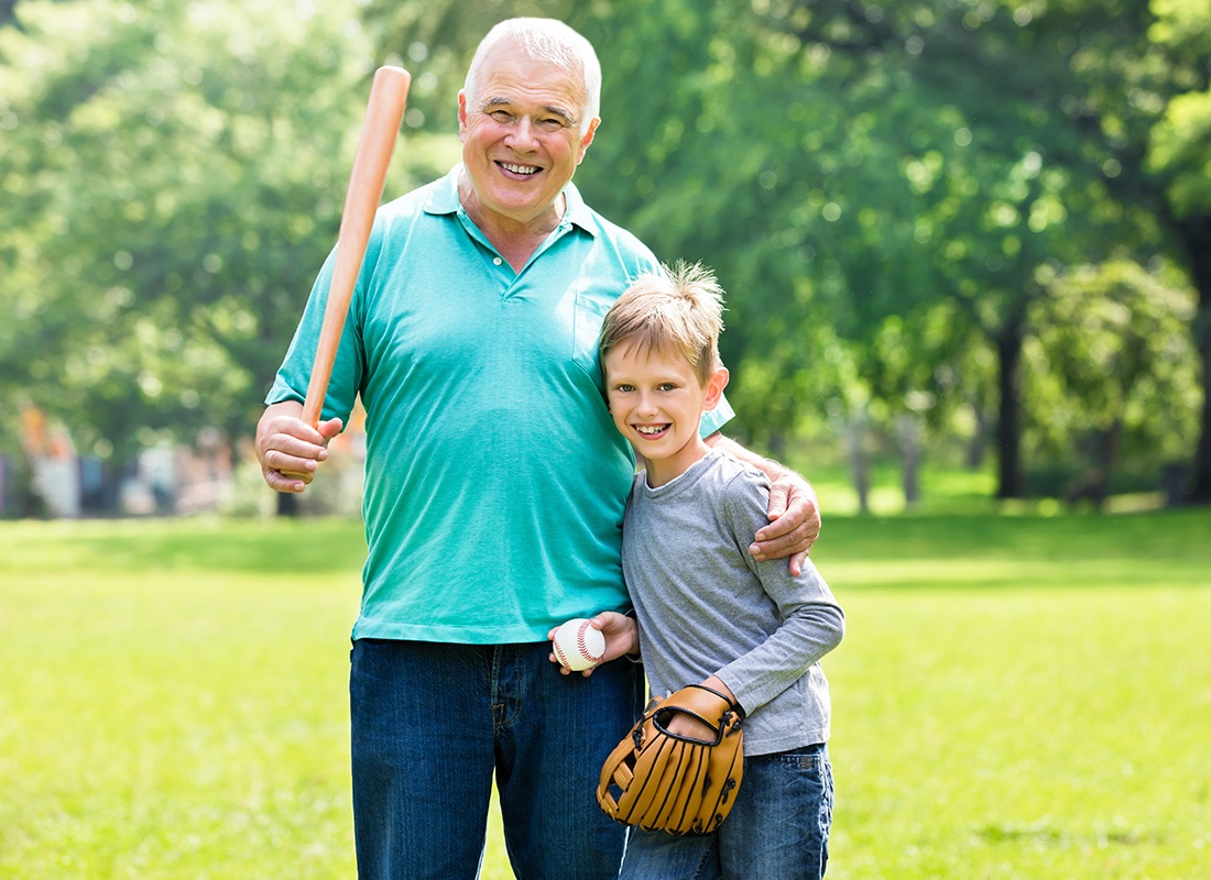 Medicare - Grandfather and Grandson Play Baseball Together at a Park